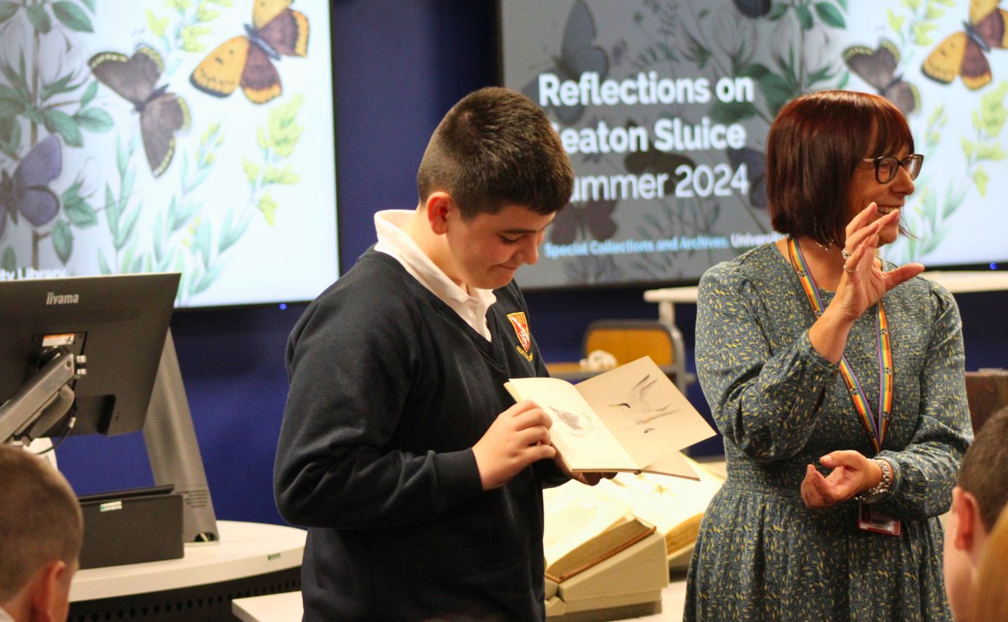 Student holding a book displaying seabirds